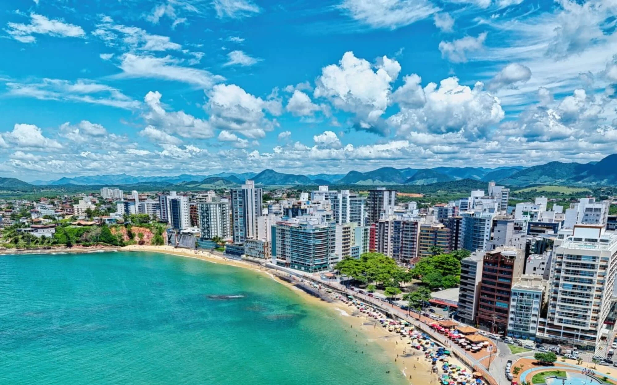 Areia escura e águas calmas da Praia da Areia Preta em Guarapari